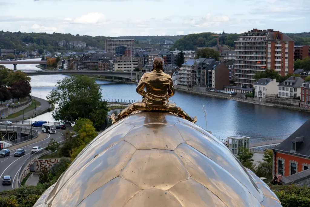 Jan Fabre's golden sculpture Searching for Utopia on the Citadel of Namur, looking over the Meuse and the city.